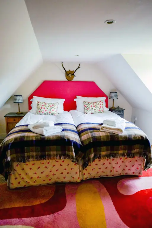 Upstairs double bedroom with pitched roof and wool blankets at Lochanshelloch Cottage