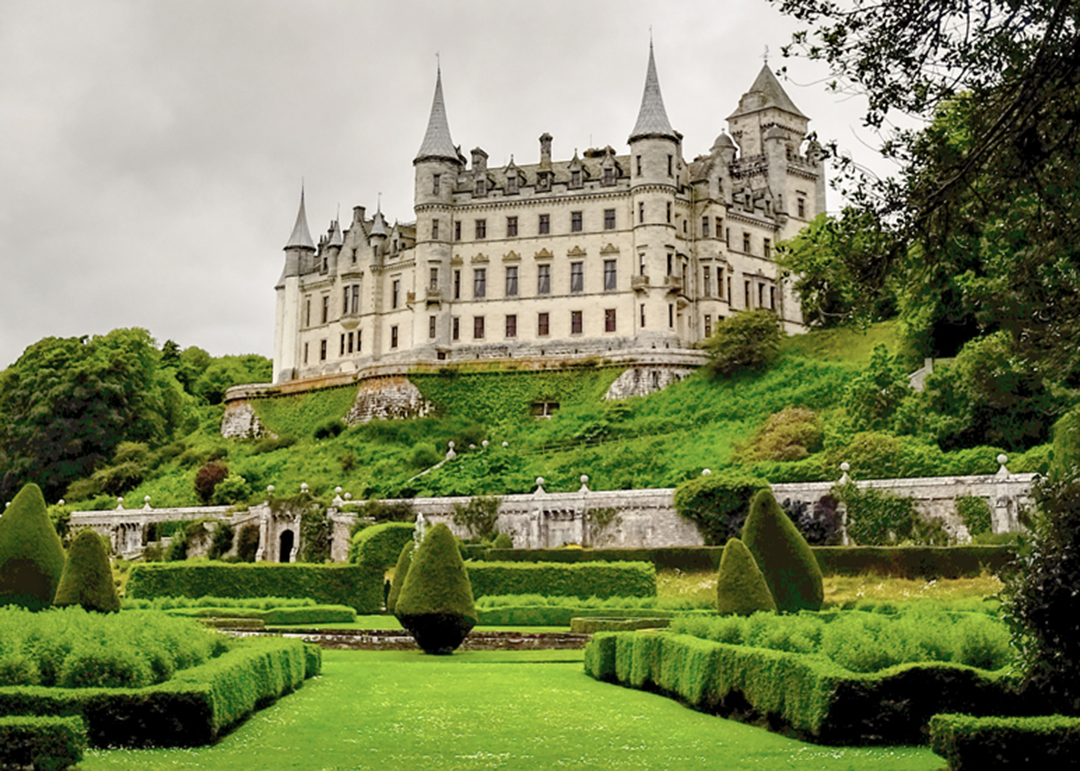 Dunrobin Castle Sutherland - picture taken from the garden looking at the castle with its turrets. The garden has lots of levels and trees. 