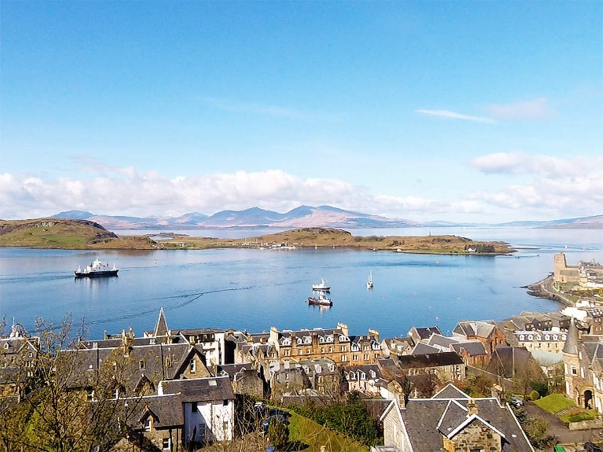 Oban harbour waterfront with fishing boats and views across the bay in Argyll