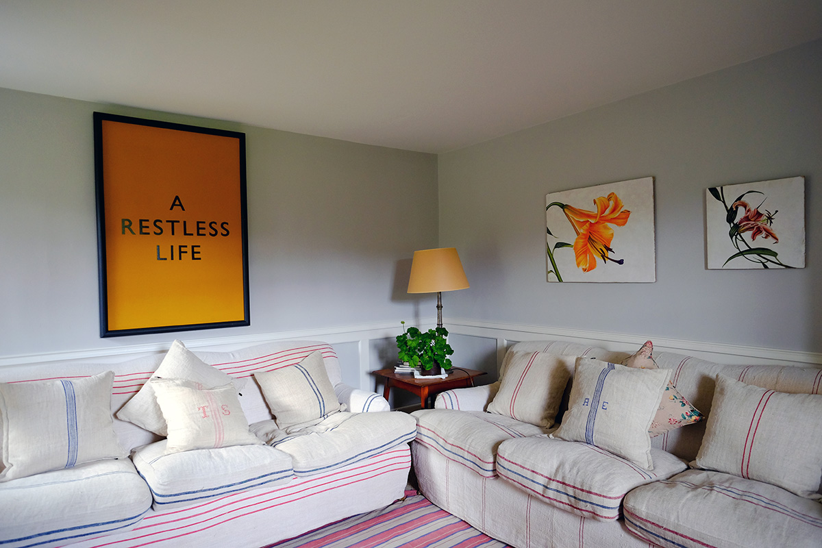 Inside Lochanshelloch Cottage - a cozy living room with art and plants.